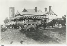 A black and white photograph of the Salvation Army Boys' Home. The building has a large veranda, and there are a group of people standing on it. In front of the building and grazing on the lawn are a group of cattle.