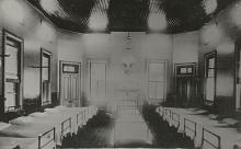 A black and white photograph of the sleeping quarters of Cootamundra Girls' Home. Beds line the left, right and centre of this room.