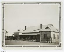 A black and white photograph of a building at Koonibba Lutheran Children's Home. The building has a stone-masonry face with a wire fence at the front.