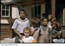 A colour photograph of several young children at Marribank Mission. They are outside in the open, standing together in a small group.