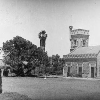 A black and white photograph of the stone-masonry front of St Francis House. There are several trees and a large lawn.